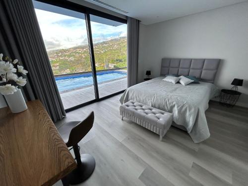 ein Schlafzimmer mit einem Bett und einem großen Fenster in der Unterkunft Art Sunset Luxuary Villa in Ribeira Brava