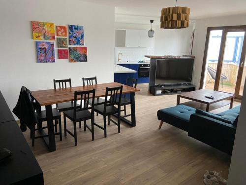 2 bedroom Apartment + Parking في سان دوني: مطبخ وغرفة معيشة مع طاولة وكراسي خشبية
