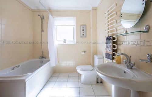 uma casa de banho com uma banheira, um WC e um lavatório. em Loch Eyre Oasis em Kensaleyre