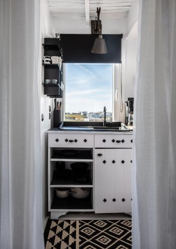 a white kitchen with a sink and a window at Captain Zeppos in Pollonia