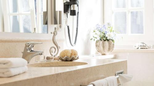 a bathroom counter with a sink and a mirror at Dorint Strandresort & Spa Westerland/Sylt in Westerland (Sylt)