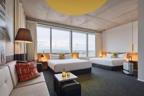 een hotelkamer met 2 bedden en een bank bij Atura Adelaide Airport in Adelaide