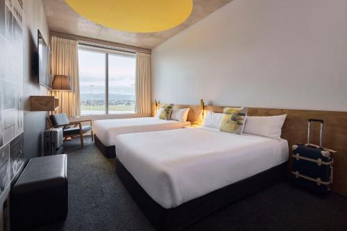 a hotel room with two beds and a window at Atura Adelaide Airport in Adelaide