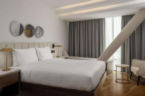 a bedroom with a large white bed and a window at Radisson Hotel & Residences Erbil in Erbil