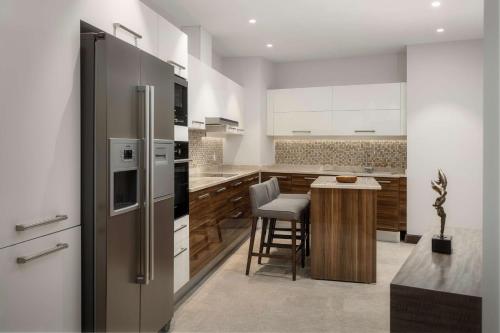 a kitchen with a refrigerator and a table with chairs at Radisson Hotel & Residences Erbil in Erbil