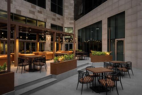 a restaurant with tables and chairs outside of a building at Radisson Hotel & Residences Erbil in Erbil