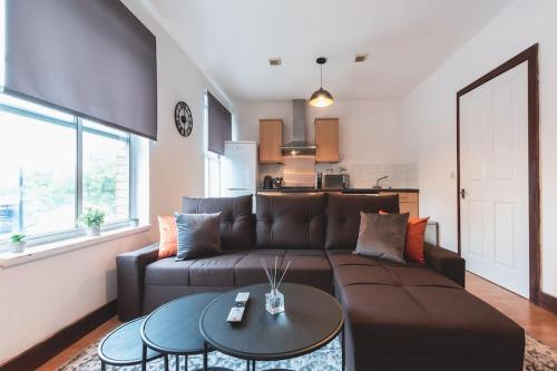 un soggiorno con divano marrone e tavolo di Noir - 2 Bedroom Flat - Sleeps 5 with Parking a Southampton