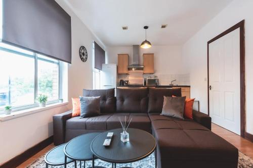 a living room with a brown couch and a table at Noir - 2 Bedroom Flat - Sleeps 5 with Parking in Southampton