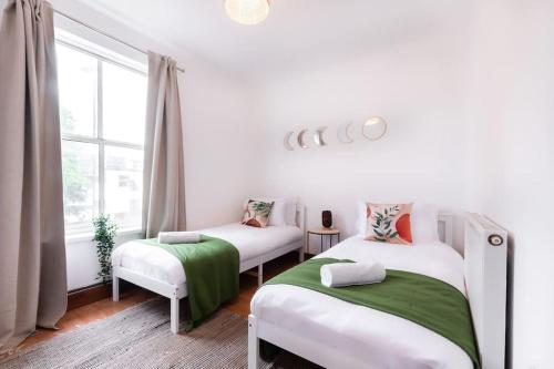 a bedroom with two beds and a window at Noir - 2 Bedroom Flat - Sleeps 5 with Parking in Southampton