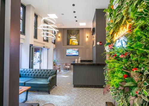 a waiting room with a blue couch and a wall of plants at BEST HOTEL KADIKOY in Istanbul