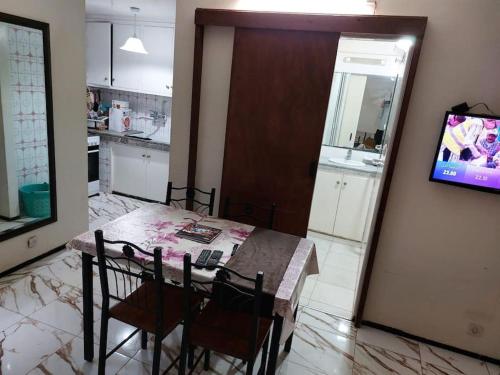 a kitchen with a table and chairs and a tv at Appartement au centre de Rabat à Hassan. in Rabat
