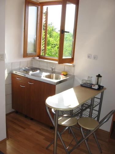 a kitchen with a sink and a table with two chairs at Apartments Sopaljska 24a in Crikvenica