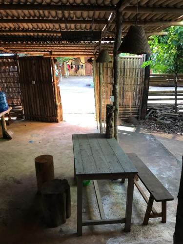 una mesa de picnic de madera y un banco en un edificio en Happy Homestay Banlung & Trekking, en Banlung