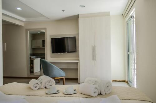 Pokój z łóżkiem z ręcznikami i telewizorem w obiekcie Porto Marina Mont Blanc Itacuruçá w mieście Itacuruçá