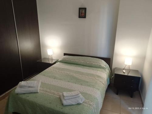 1 dormitorio con 1 cama con 2 toallas en Loft Plaza Belgrano en San Miguel de Tucumán