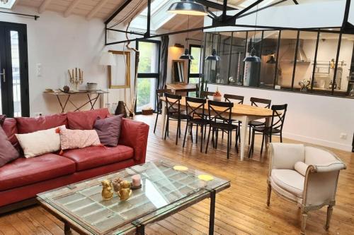 un salon avec un canapé rouge et une table dans l'établissement Maison et studio indépendant - Chez Lulu, à Vertou