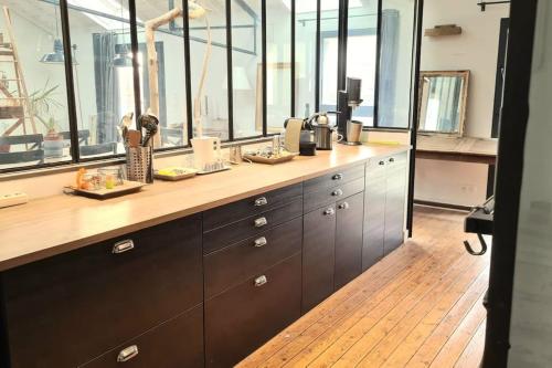 a kitchen with a counter with a bunch of windows at Maison et studio indépendant - Chez Lulu in Vertou