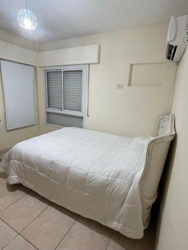 een wit bed in een kamer met een raam bij Temporarios Chaco in Resistencia