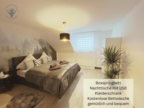 a bedroom with a bed and a potted plant at PSApartment am Pfälzer Wald nähe Outlet Center Zweibrücken in Pirmasens