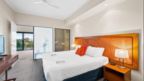 um quarto com uma cama grande e uma televisão em Sea Side 205 em Mandurah