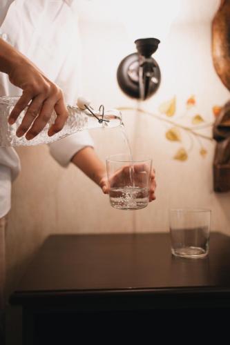 a woman pouring a glass of water from a faucet at Los Pilares Hotel in Oaxaca City