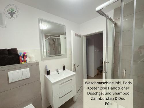 uma casa de banho branca com um chuveiro e um lavatório. em PSApartment am Pfälzer Wald nähe Outlet Center Zweibrücken em Pirmasens