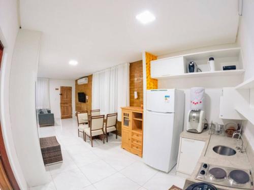 Una cocina con un refrigerador blanco y una mesa. en Flat na natureza, en Bonito