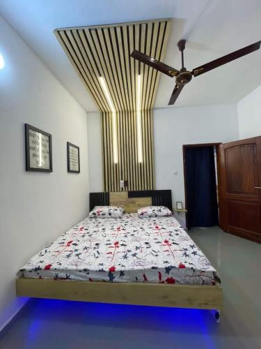 1 dormitorio con 1 cama grande y ventilador de techo en Entrée personnelle 2 chambres, en Cotonou