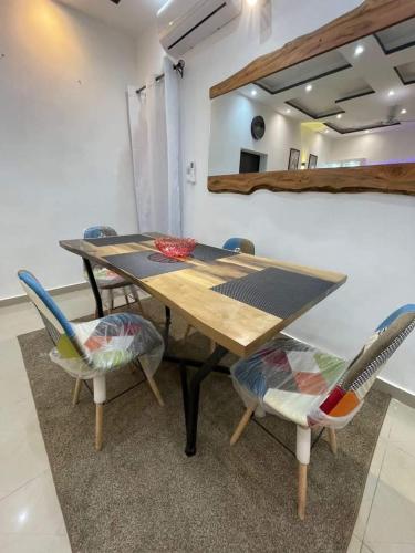 comedor con mesa de madera y sillas en Entrée personnelle 2 chambres, en Cotonou