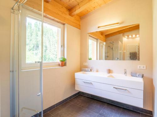 ein Bad mit einem Waschbecken und einer Glasdusche in der Unterkunft Drei Berge Top 7 in Saalbach-Hinterglemm
