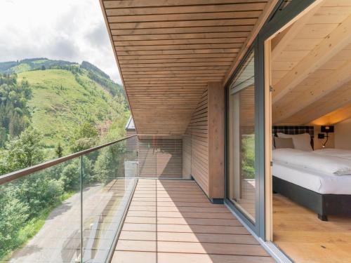 a room with a balcony with a bed and a view at Schmittenblick 5 in Viehhofen