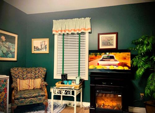 a living room with a tv and a chair at WeatherPine Inn in Niagara on the Lake