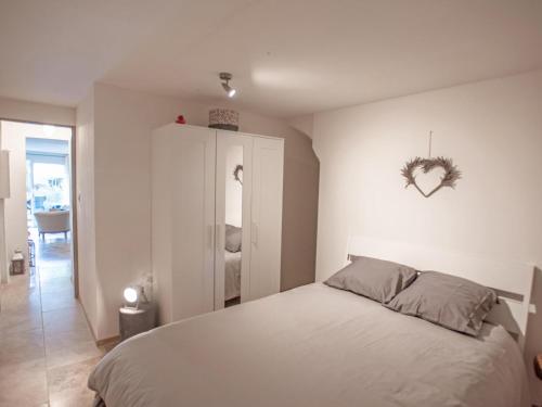 1 dormitorio con 1 cama con un signo cardiaco en la pared en La Pinede, en Faucon