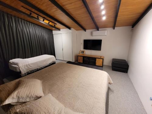 - une chambre avec 2 lits et une télévision à écran plat dans l'établissement Casa sobre el río, à Posadas