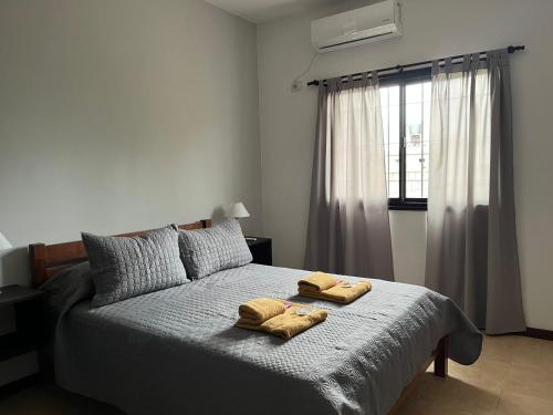 a bedroom with a bed with two towels on it at Departamento TALA - excelente nivel, con patio in San Fernando del Valle de Catamarca