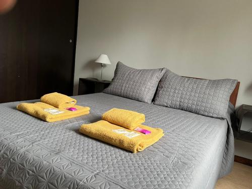 ein Bett mit zwei gelben Handtüchern darüber in der Unterkunft Departamento TALA - excelente nivel, con patio in San Fernando del Valle de Catamarca