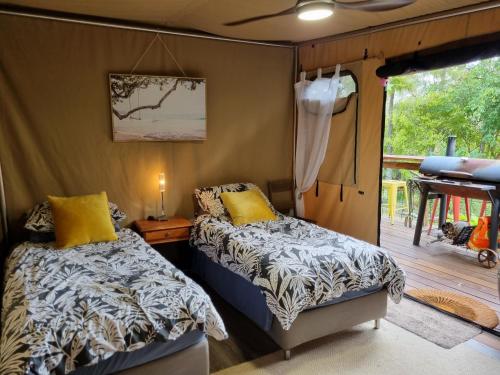 a bedroom with two beds and a balcony at Birdsong Retreat - A BnB on Lamb Island 