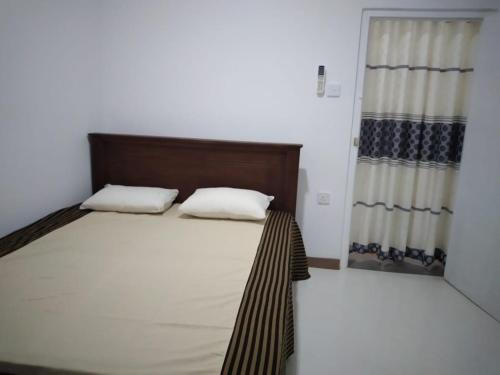 a bedroom with a bed with two pillows and a window at Cosy Holiday Home in Jayarajapuraya