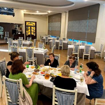 un gruppo di persone sedute a un tavolo che mangiano di Welcome генацвале))) a Tbilisi City