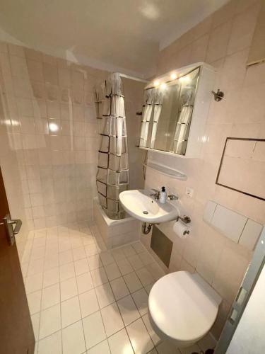 ein weißes Bad mit einem WC und einem Waschbecken in der Unterkunft Wohnen mit Panoramablick in Kornwestheim
