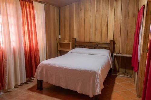 - une petite chambre avec un lit et des murs en bois dans l'établissement Cabaña Campo Verde, à Marsella