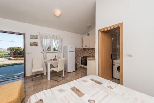 sypialnia z łóżkiem i kuchnia ze stołem w obiekcie Apartments by the sea Seline, Paklenica - 6564 w mieście Starigrad-Paklenica