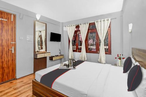 Collection O Hotel Priyatam Nirwana tesisinde bir odada yatak veya yataklar