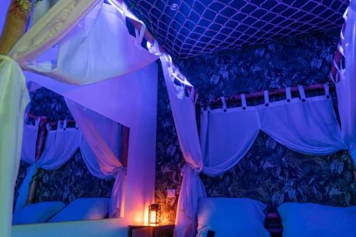 a room with a bed with purple lighting at Tropical Jungle Loveroom Pau centre in Pau