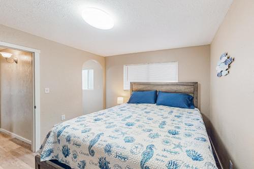 um quarto com uma cama com almofadas azuis em Little Wygant Road Retreat em Coos Bay