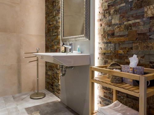 La salle de bains est pourvue d'un lavabo et d'un mur en briques. dans l'établissement Gîte Ligné, 5 pièces, 9 personnes - FR-1-306-866, à Ligné