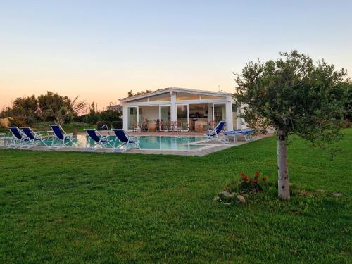 a house with a pool and chairs in a yard at 309 Le Saline - Stintino in Stintino