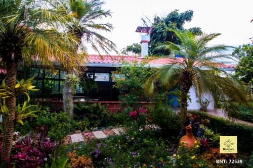 a garden with palm trees and flowers in front of a building at Bosques de la Pradera in Manizales