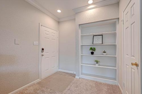 a hallway with a white door and shelves at Houston's City Center Apartment (5-Min Drive from Med Center) in Houston