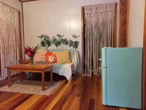 a living room with a bed and a refrigerator at Mariposa Jungle Lodge in San Ignacio